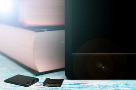 A modern e-book and small memory cards with books in the background