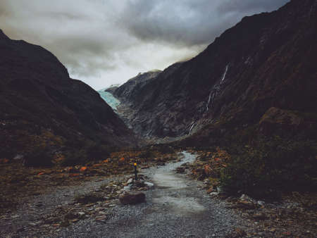 A pathway in the middle of two mountains on a cloudy dayの写真素材