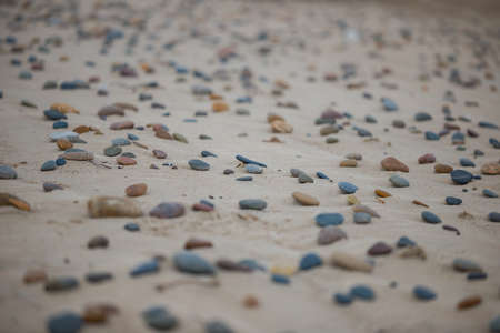 Many colorful pebbles on the sand during daytime
