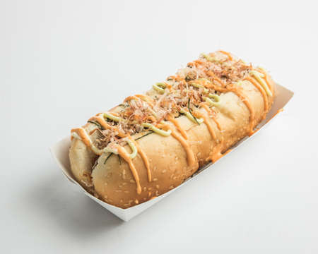A closeup shot of a sandwich with chicken and sauce on top of it on a white surfaceの写真素材