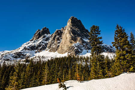 A beautiful shot of high rocky mountains and hills covered in snow leftover in Springの写真素材