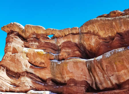 A closeup of high rocks in a desert with amazing textures and a blue sky in the background