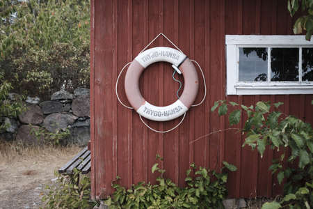 A lifesaver ring on a little hut in a forest near a seaの写真素材