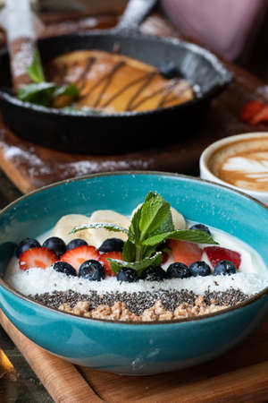 The blue bowl with cereal and various  delicious fruitsの写真素材