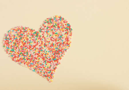 Colorful candies shaping a heart with space for text on left - Valentine's Day