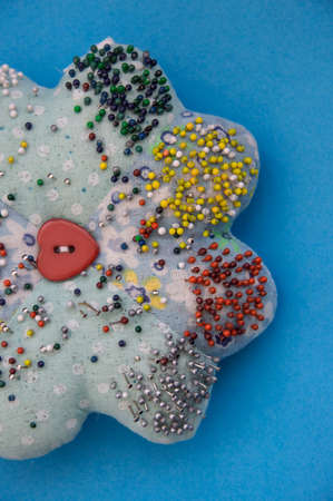 A closeup shot of a star-shaped pillow for needles on a blue surface