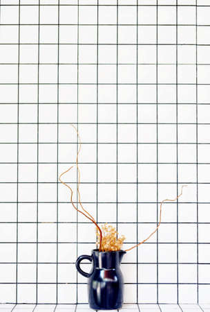 Long exposure shot of liquid splash from a blue vase on a cool white tile background