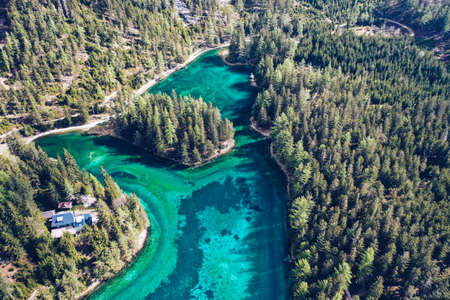 A beautiful aerial shot of a blue river running in a forest