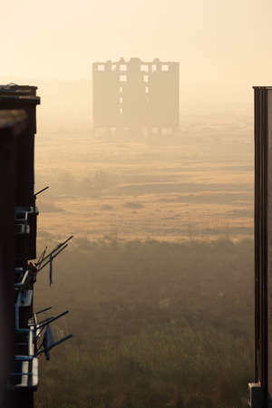 A vertical shot of an old abandoned building in the distance