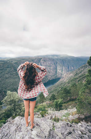 A vertical shot of a young Caucasian woman in Sil Canyon in Spainの写真素材