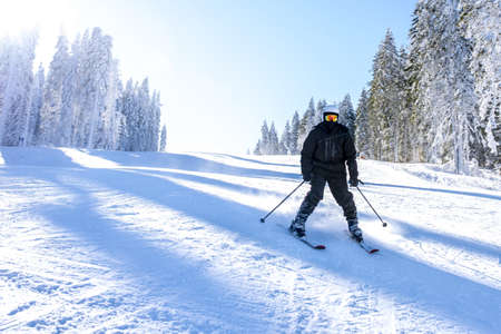 A skier in motion with a beautiful winter landscape in the backgroundの写真素材