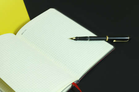 Vintage pen and a notebook with a red ribbon artistic wallpaper. background