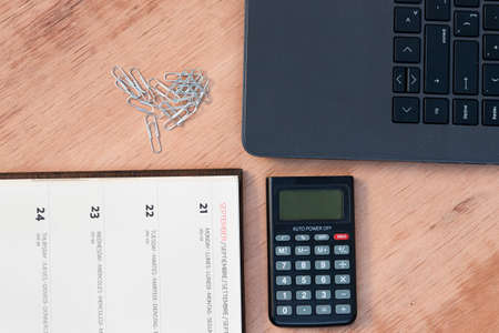 The office supplies and gadgets on a wooden desk to work from home because of Covid-19 pandemic