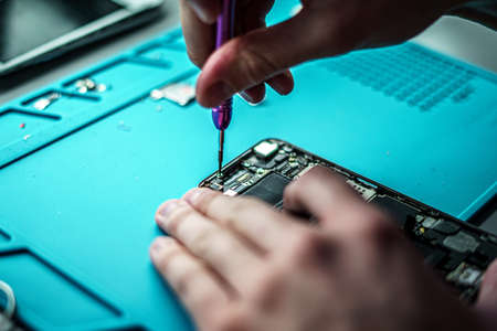 A closeup shot of a specialist repairing a mobile phoneの写真素材