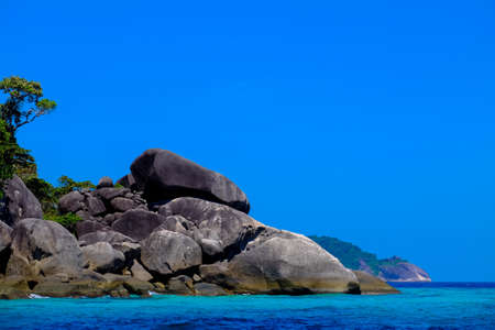 A big rocks and trees near the sea with clear sky n the backgroundの写真素材