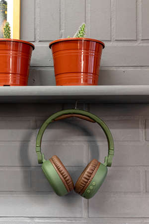The green headphones hanging from a table decorated with plant potsの写真素材