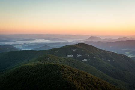 A beautiful shot of green mountains in summer and the morning sky in the backgroundの写真素材