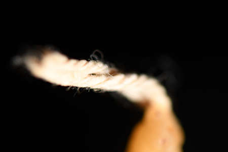 A closeup shot of a candle with a black backgroundの写真素材