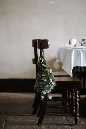 A vertical shot of a green plant hanged on a wooden chairの写真素材