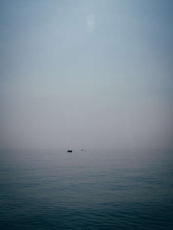 A vertical shot of a boat resting on the water at the coast of Salerno, Italy.の写真素材