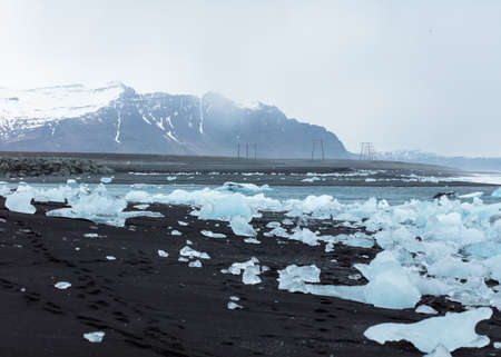 Ice particles on the beach with beautiful mountains in the backgroundの写真素材