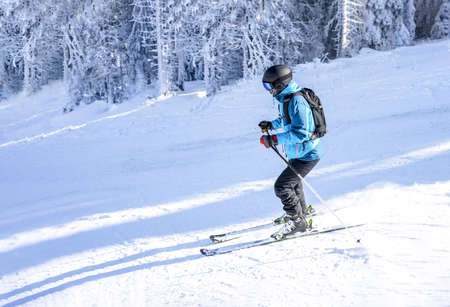 A skier riding downhill in a mountain resort