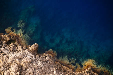 A beautiful overhead shot of rocky cliffs of the sea on a sunny day