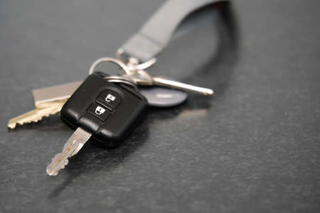 A closeup shot of a bundle of keys to a car on a black surface