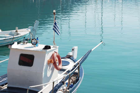 A closeup of a boat resting on the water on a sunny day at Greek islandsの写真素材