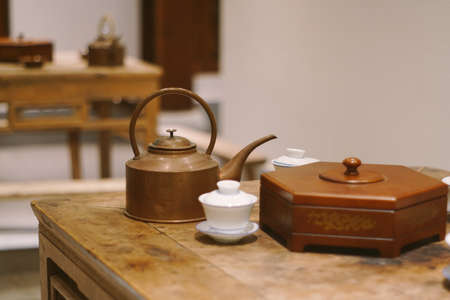 A teapot next to white cups and containersの写真素材
