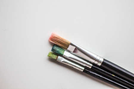 A closeup shot of paintbrushes on a white surface with a copy spaceの写真素材