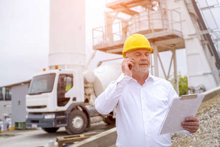 A civil engineer wearing safety helmet at the ready mix concrete plantの写真素材
