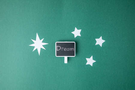 A cute bookmark with "Dream" writing and paper stars on a light green backgroundの写真素材