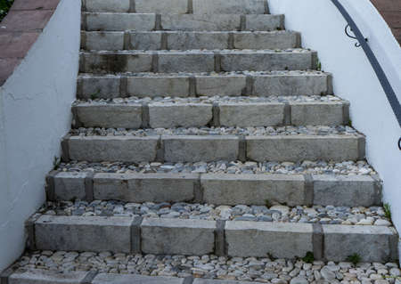 A closeup shot of concrete stairs with pebble rocks