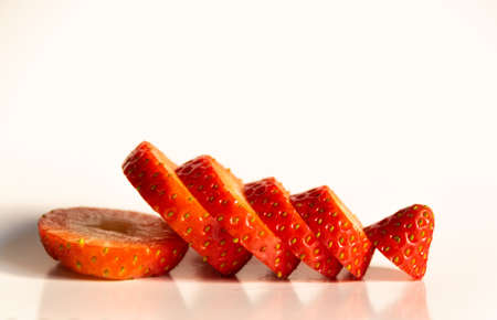 A closeup shot of sliced fresh strawberry isolated on a white backgroundの写真素材