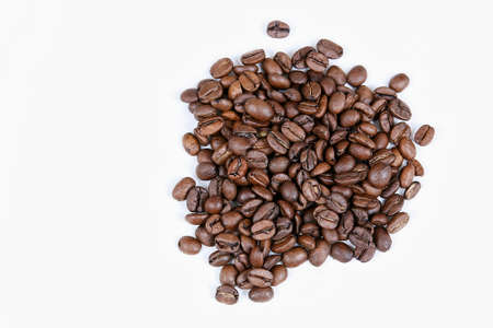A top view of roasted coffee beans on a white backgroundの写真素材