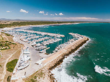 An aerial shot of a dock with many boats docked in the waterの写真素材