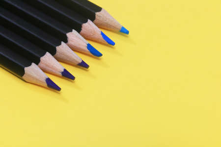 Shades of blue pencils on a yellow backgroundの写真素材