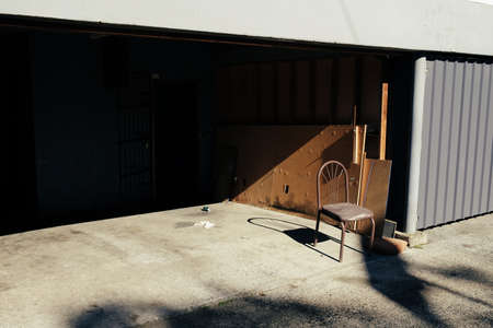 Single chair in front of an empty garageの写真素材