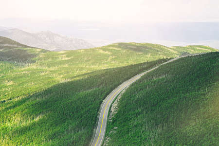 An aerial shot of a beautiful green field with a narrow road in the middle - beautiful natural...