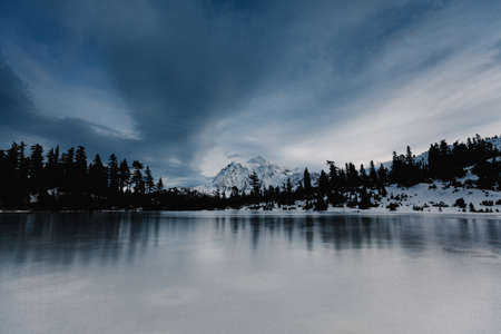 Beautiful frozen lake with breathtaking sky and greenery around. Amazing landscapeの写真素材