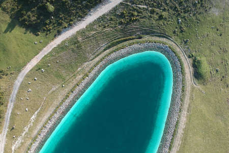 A beautiful clear blue lake in a green field shot from aboveの写真素材