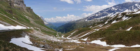 A panoramic shot of a mountain landscape on a cloudy sky backgroundの写真素材