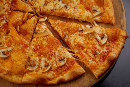 Closeup of mushroom pizza slices on a wooden pizza plateの写真素材
