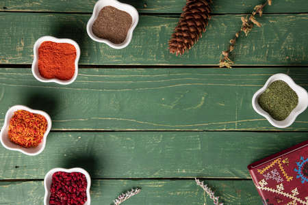 Spices in a white bowl on green wooden surfaceの写真素材