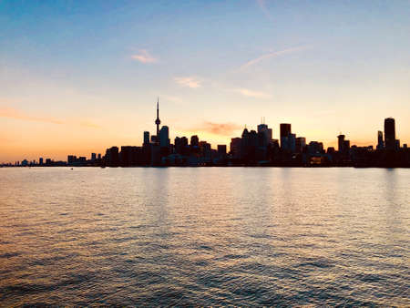 A wide shot of beautiful urban city skyline taken at sunset with the pretty sky and the seaの写真素材