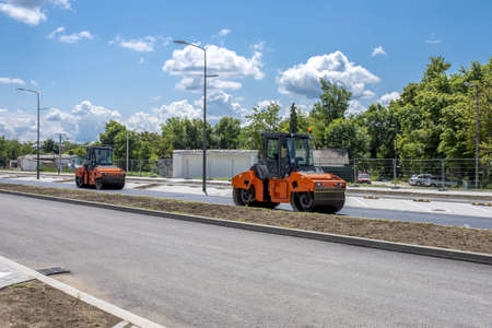 A group of road-rollers on the fresh asphalt under the sunlight at daytime