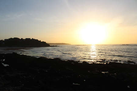 A silhouette of the shore near the water with a beautiful sky in the backgroundの写真素材