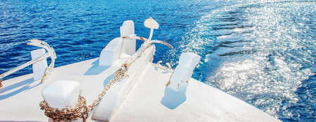 A wide cut closeup shot of a white yacht on clear blue sea