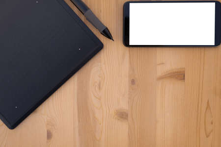 A top view of graphic tablet and smartphone on wooden backgroundの写真素材